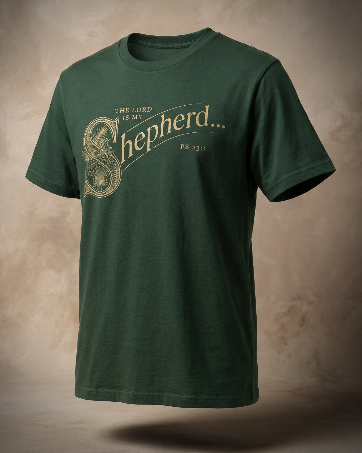 The Lord Is My Shepherd t-shirt in forest green with gold ornamental lettering and Ps 23:1, three-quarter studio view